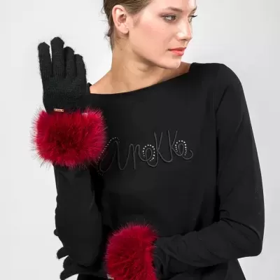 Mulher com luvas pretas e punhos em pelúcia vermelha vestindo camisola preta