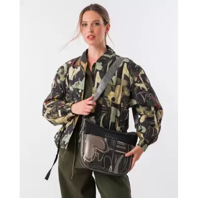 Mulher com casaco camuflado e mala de ombro padrão abstrato