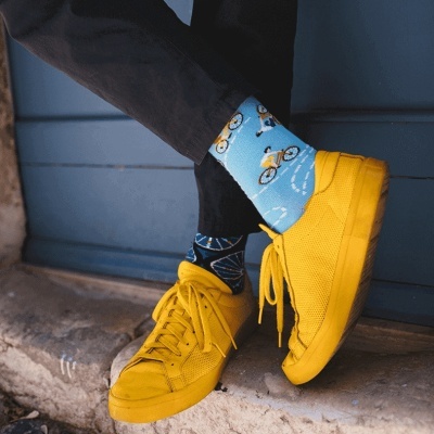 Meias coloridas com padrão de bicicletas usadas com sapatos amarelos