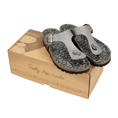 Sandálias prateadas com sola preta e padrão interior preto e cinza sobre caixa castanha com texto