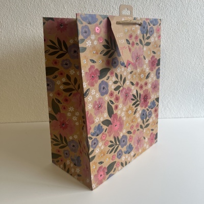 Saco de presente em papel kraft com padrão de flores coloridas e alças de corda