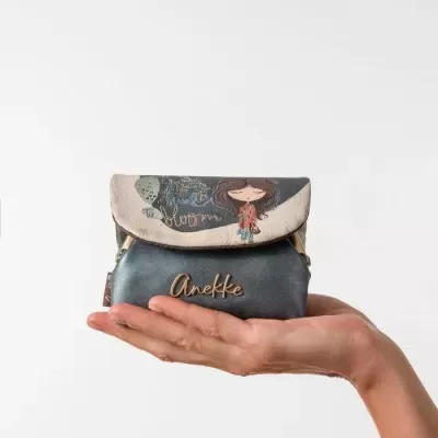 Carteira pequena azul escuro e bege com personagem feminina e texto, nome Anekke em dourado, segurada por mão