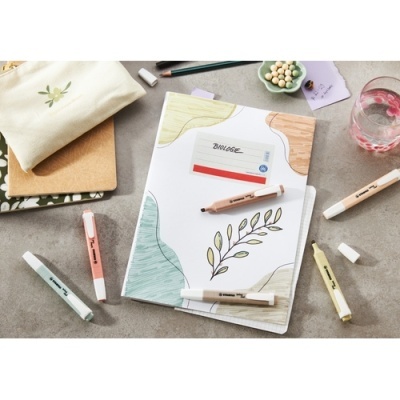 Caderno decorado e canetas coloridas numa superfície cinzenta