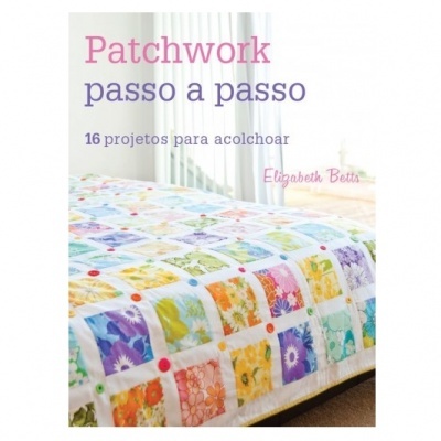 Livro de patchwork com capa mostrando colcha colorida com padrões florais sobre cama