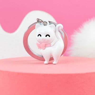Porta-chaves com pendente de gato branco com laço cor-de-rosa em fundo cor-de-rosa
