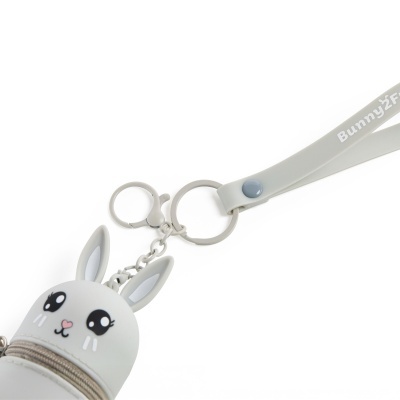 Chaveiro em silicone cinzento em forma de cabeça de coelho com olhos grandes e nariz rosa