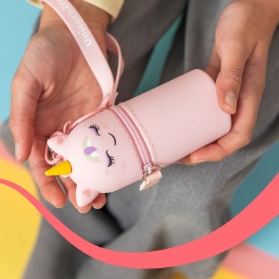 Estojo rosa forma unicórnio com chifre amarelo fechado nas mãos