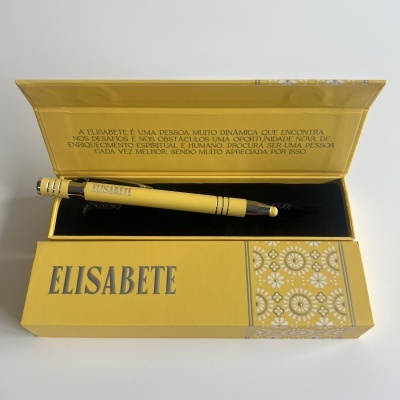 Caneta amarela com caixa amarela decorada, texto em português sobre Elisabete