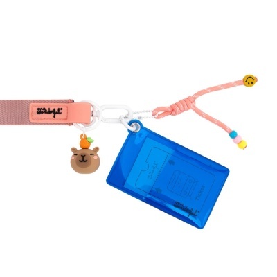Correia rosa com pendente de urso, bolsa azul para bilhetes e cordão cor-de-rosa com smiley.
