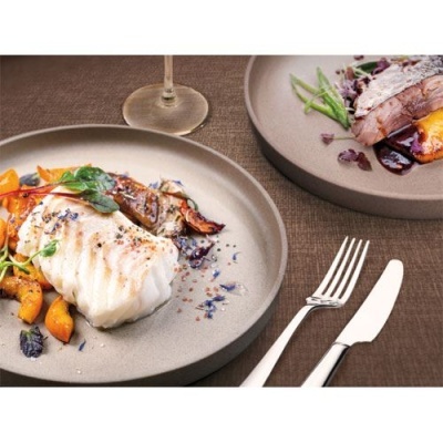 Pratos de cerâmica cinza com comida gourmet, talheres prateados e taça de vidro