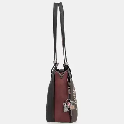 Mala de ombro castanho e preto com alças finas e pendente decorativo