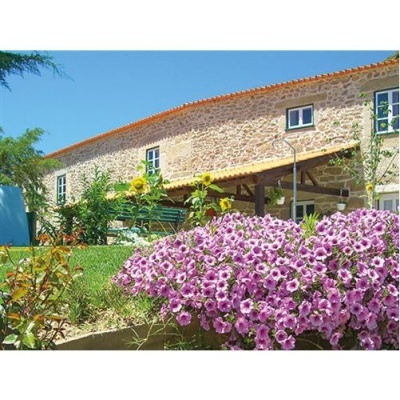 Casa rústica com flores cor-de-rosa e girassóis no jardim