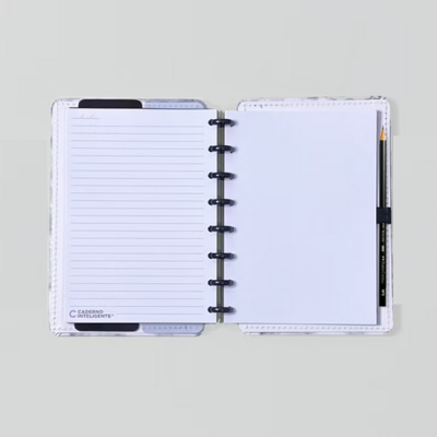 Caderno inteligente aberto com folhas pautadas e em branco, suporte para lápis preto, sobre fundo cinzento claro