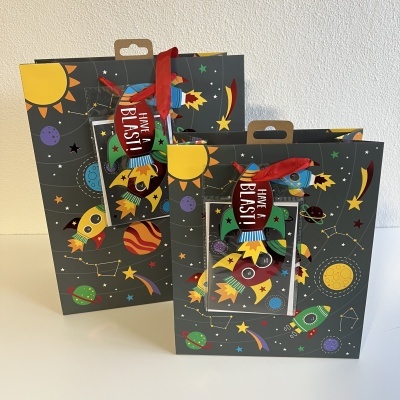 Bolsas de presente tema espaço com etiquetas vermelhas e ilustrações coloridas