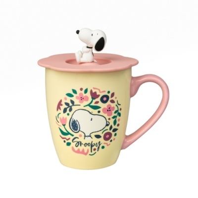 Caneca amarela com pega rosa, tampa com figura do Snoopy e decoração floral colorida