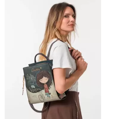 Mochila azul escuro e creme com ilustração de menina e texto, usada por mulher com t-shirt branca