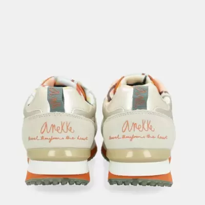 Ténis bege claro com detalhes laranja e texto Anekke na parte traseira