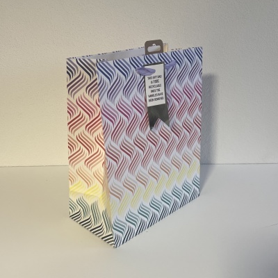 Saco de papel colorido com padrão ondulado e etiqueta preta pendurada