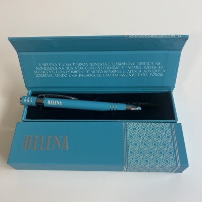 Caneta azul turquesa personalizada com o nome Helena dentro de caixa azul turquesa com texto em português