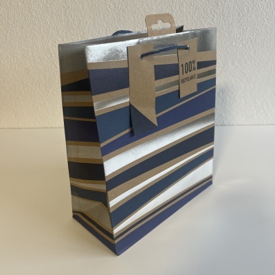 Saco de papel para presente com riscas azul escuro, prateado e castanho e etiqueta '100% RECICLÁVEL'