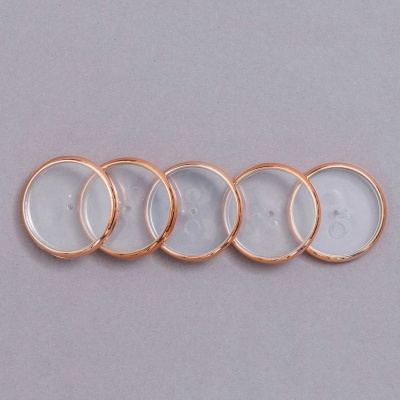 Cinco lentes transparentes redondas com bordas cor cobre sobre fundo cinza.