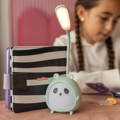 Lâmpada de leitura panda verde com luz LED ao lado de uma agenda preta e branca Back2Fun
