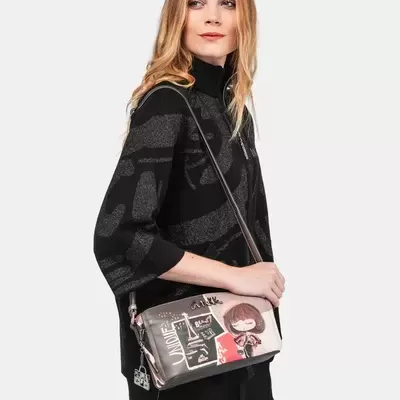 Mochila feminina cinza com estampas e alça fina, usada por modelo