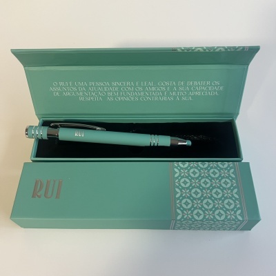 Caneta verde água com caixa decorada e texto com mensagem sobre Rui