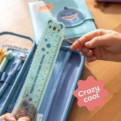 Régua azul com forma de urso e confetes coloridos, texto Keep calm and relax, junto a estojo azul com canetas