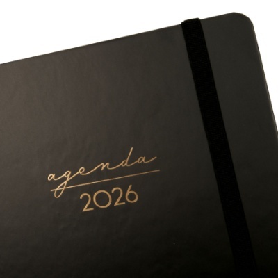 Agenda preta com texto dourado agenda 2026 e elástico preto