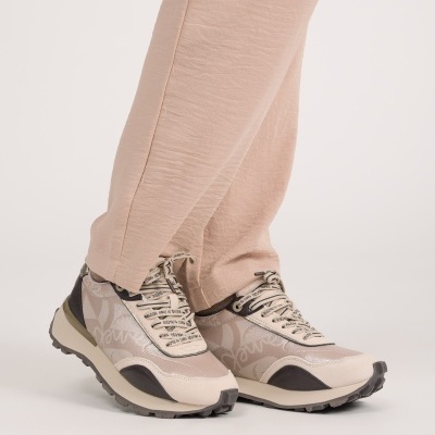 Ténis bege e castanho usados com calças bege.