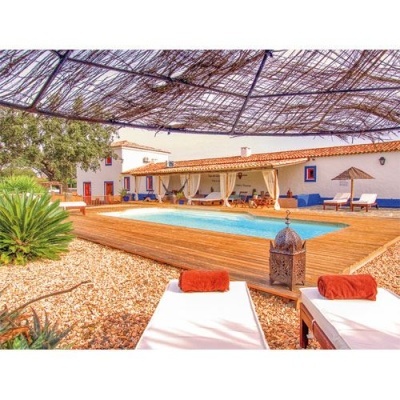 Piscina exterior com espreguiçadeiras brancas e toldo de ramos entrelaçados