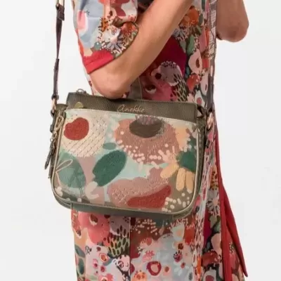 Mala de tiracolo floral colorida com logotipo Anekke usada por pessoa com roupa floral