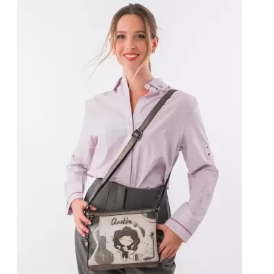 Mulher com camisa rosa claro e mala tiracolo Anekke bege com ilustração