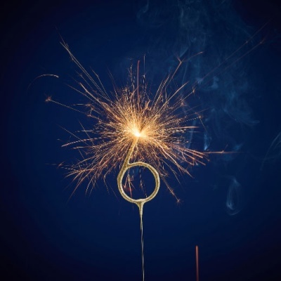 Vela de número 6 dourada com faíscas acesa