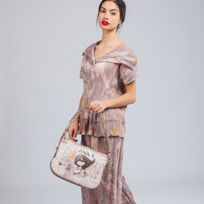 Mulher com conjunto rosa dourado e bolsa bege com ilustração e texto Annbe