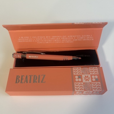 Conjunto caneta e caixa cor salmão com padrão floral e texto BEATRIZ