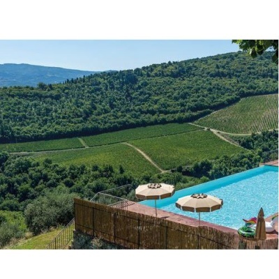 Piscina exterior com umbrelas e vista para colinas verdes