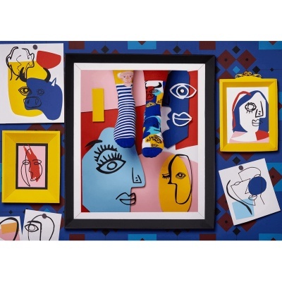 Meias coloridas com padrões abstratos e faces suspensas em fundo artístico com molduras