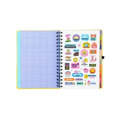 Caderno espiral aberto com adesivos coloridos e página quadriculada azul