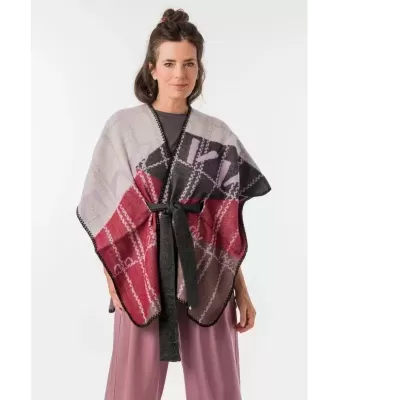 Poncho multiusos em tecido com padrão geométrico e cinto preto usado por mulher.
