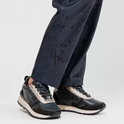 Sapatos desportivos azuis e bege com sola clara usados com calças azul marinho