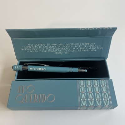 Caneta azul clara em caixa azul com texto 'AVÓ QUERIDO' e dedicatória na tampa