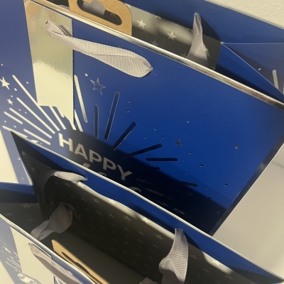 Sacos de oferta azuis com texto 'HAPPY' e padrão de estrelas