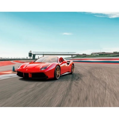 Carro desportivo vermelho numa pista de corridas sob céu azul