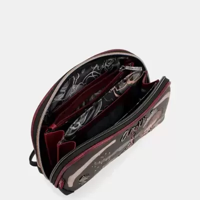 Carteira preta, castanha e bordô aberta a mostrar interior com estampado preto e branco e vários compartimentos