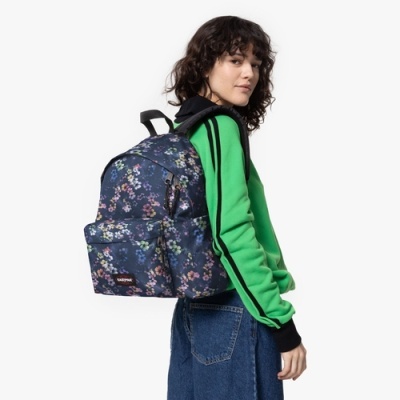 Mochila Tosca Eastpak azul com padrão floral usada por mulher em fundo branco.
