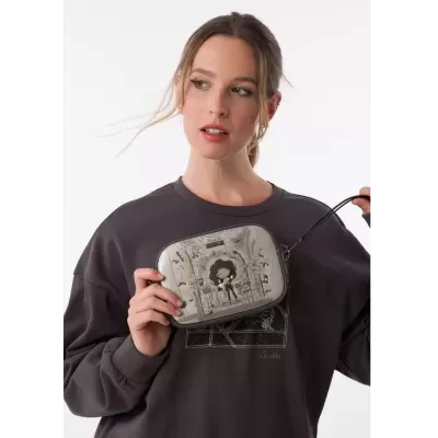 Mala de mão cinza com ilustração e mulher a segurá-la vestindo sweatshirt cinza escura