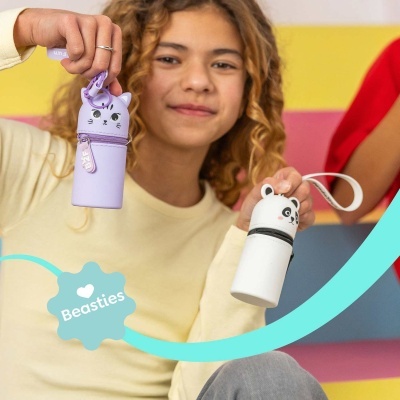 Dois porta-moedas de silicone com rosto de animais segurados por uma jovem com fundo colorido