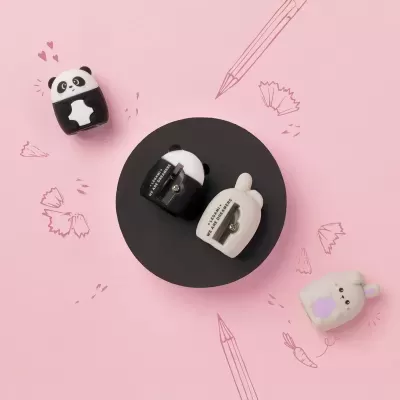 Apontadores de lápis decorativos em formas de panda e outros animais, fundo rosa com desenhos